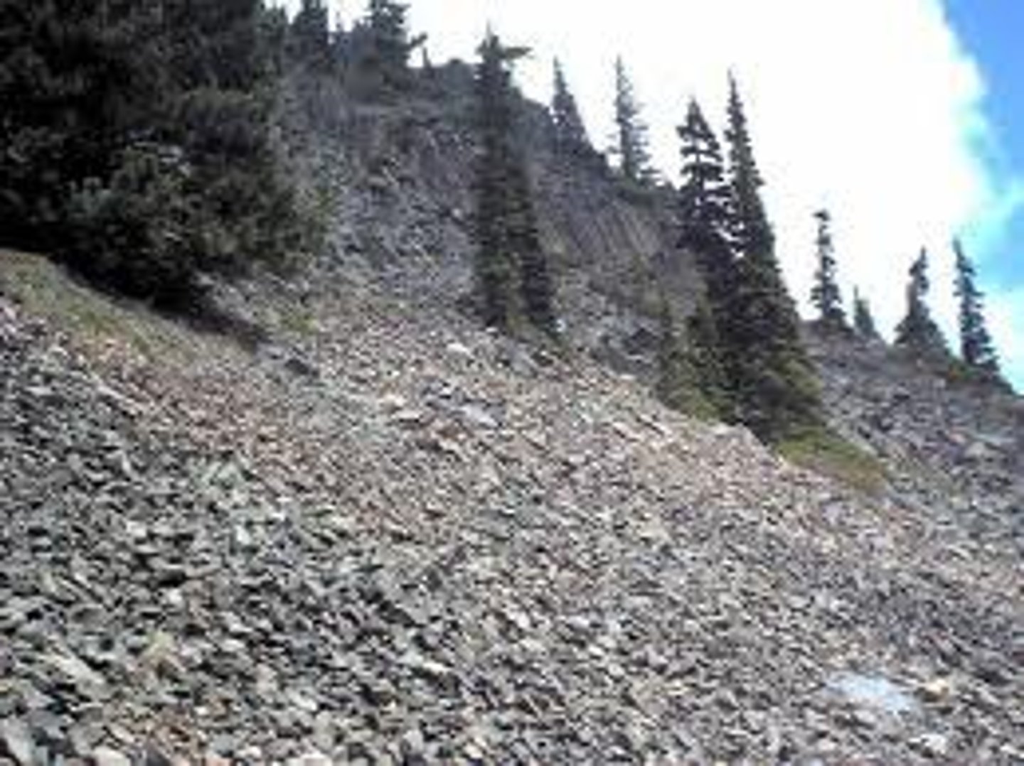 <p>A collection of broken rock fragments at the base of mountains.</p>
