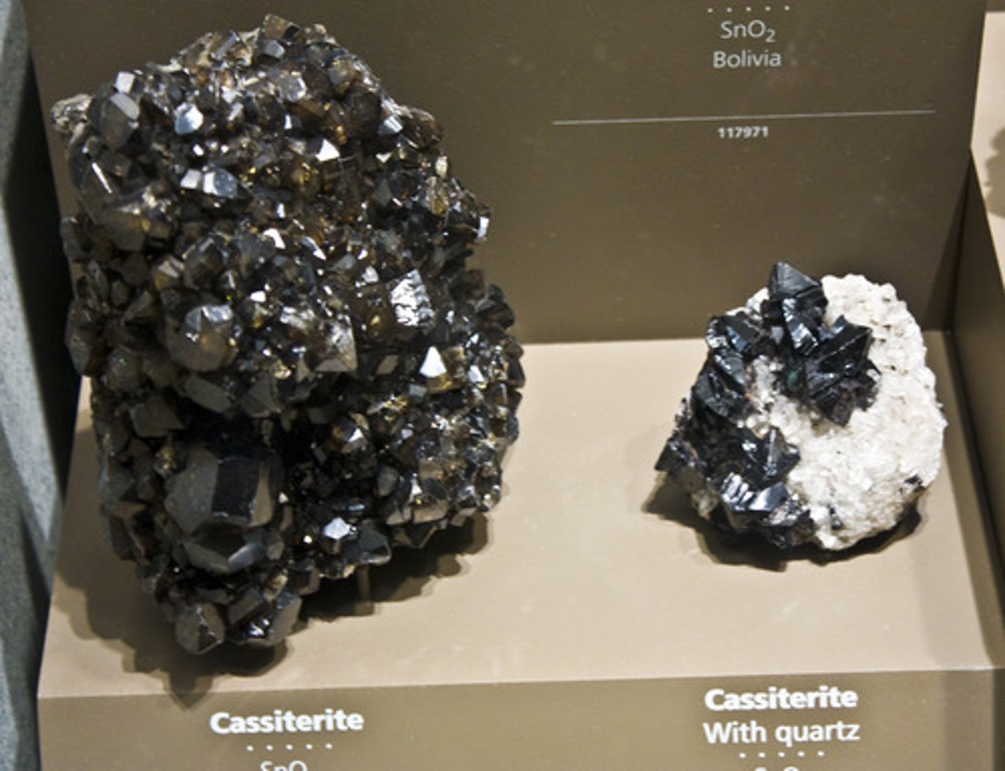 <p>Rutile group.<br>Tetragonal.<br>Massive granular, reniform, radiating wood appearance (wood tin). Also called visor tin.<br>H = 6-7<br>SG = 6.8-7.1<br>Translucent (rarely transparent).<br>Adamantine to sub-metallic and dull luster.<br>Color = brown or black; rarely yellow or white.<br>Streak = white.</p>