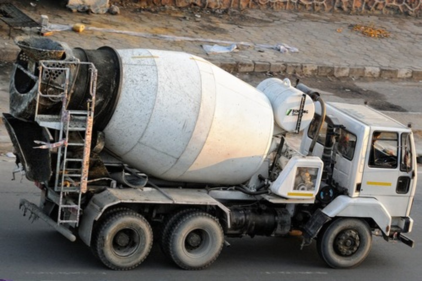 <p>a machine that mixes concrete ingredients by means of a rotating drum. raw materials are introduced into the mixing drum through its open end and discharged by tilting the mixing drum to allow the concrete to pour out</p>