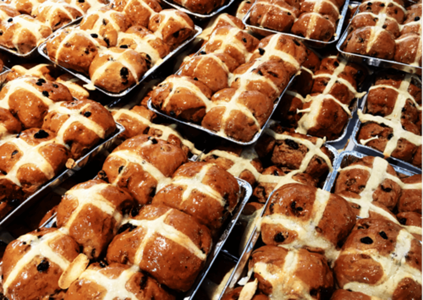 <p>cook a sweet bun with a cross on top, usually eaten at Easter</p>