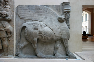 <ul><li><p><u><strong>Form</strong></u></p><ul><li><p>Human-headed animal guardian figures: face of a person, ears and body of a bull.</p></li><li><p>Winged.</p></li><li><p>Appears to have five legs: when seen from the front, it seems to be standing at attention; when seen from the side, the animal seems to be walking.</p></li><li><p>Faces exude calm, serenity, and harmony.</p></li></ul></li><li><p><u><strong>Materials</strong></u></p><ul><li><p>Carved from a single piece of stone.</p></li><li><p>Meant to hold up the walls and arch of a gate.</p></li><li><p>Stone is rare in Mesopotamian art and contrasts greatly with the mud-brick construction of the palace.</p></li></ul></li><li><p><u><strong>Function</strong></u></p><ul><li><p>Meant to ward off enemies both visible and invisible from the palace of sargon or the gate or the city.</p></li><li><p>Inscriptions in cuneiform at the bottom portion of the lamassu declare the power of the king and curse his enemies.</p></li></ul></li><li><p><u><strong>Context</strong></u></p><ul><li><p>Sargon II founded the capital at <strong>Khorsabad</strong>; the city was surrounded by a wall with seven gates.</p></li><li><p>The protective spirits (guardians) were placed at either side of each gate.</p></li></ul></li></ul>