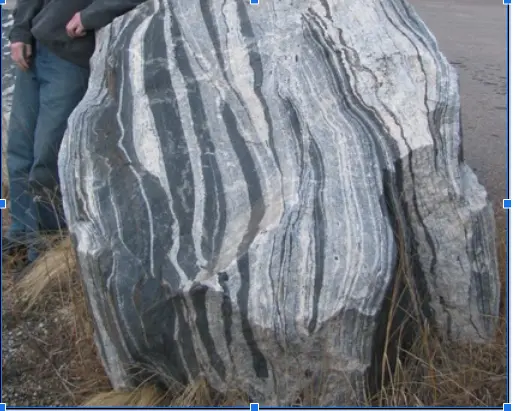 a texture defined by the alignment of platy minerals (i.e., micas), or the creation of alternating light/dark bands
