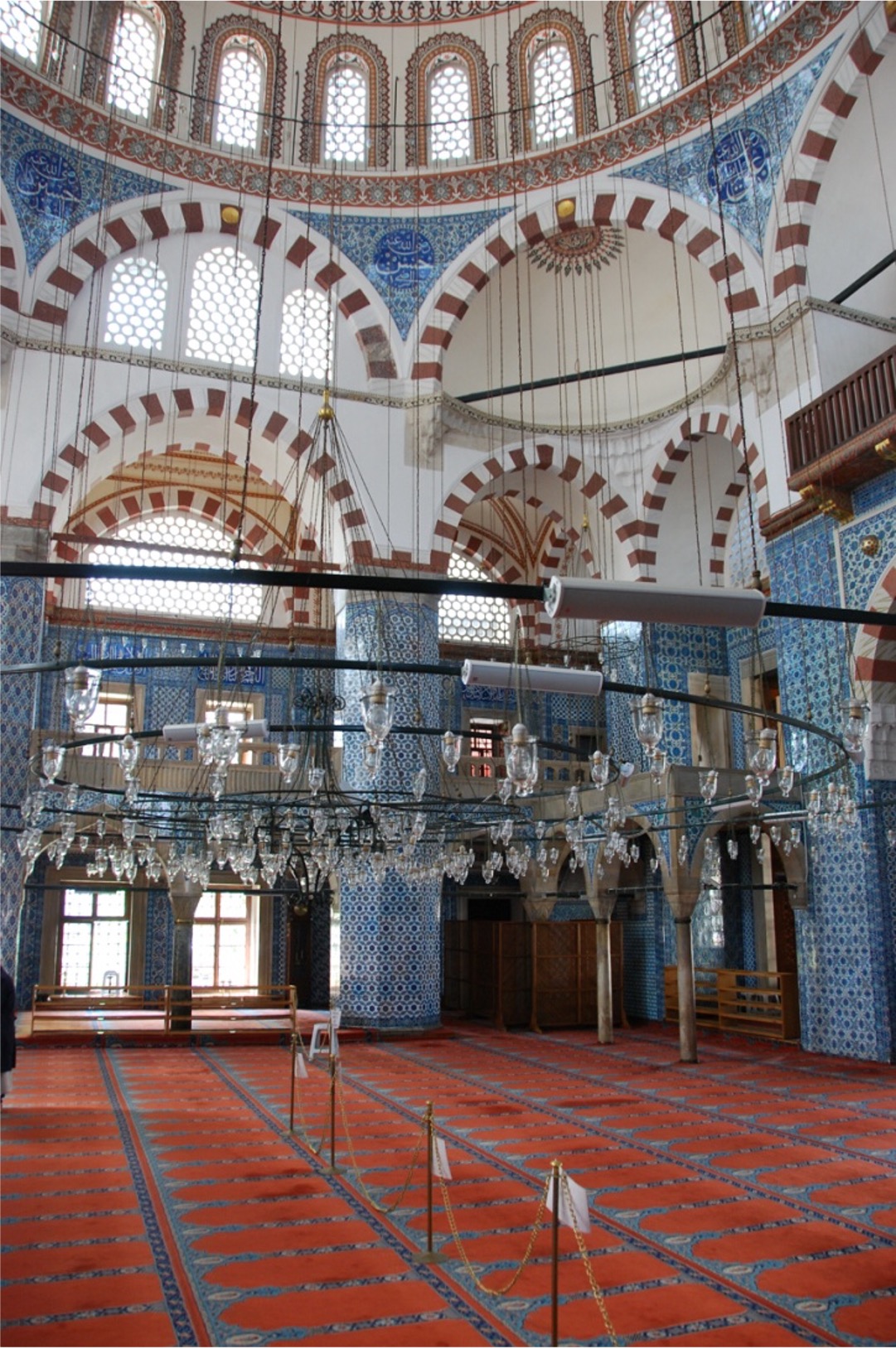 <ul><li><p>Plan shows space issues – courtyard wraps around the mosque to make a side entrance, because it sits on the 2nd floor of the building structure</p><ul><li><p>Built there b/c there was no land available</p></li><li><p>You must go through a small portal in the street and up a flight of stairs to get to mosque</p></li></ul></li><li><p>Continuing to play w/ canopy dome issue, Sinan decides to place the dome at Rüstem Paşa Camii on eight supports – 4 are incorporated into walls, and 4 act as columns to delineate the center space from the side aisles</p></li><li><p>The interior is much busier than at Süleymaniye</p><ul><li><p>This is due in part to the fact that Rüstem Paşa was fabulously wealthy and bought entire loads of Iznik tiles to decorate his mosque</p><ul><li><p>Not as “classical” as his other mosques, but Rüstem is a popular tourist attraction b/c of its “jewel box” quality</p></li></ul></li></ul></li><li><p>Scale is much smaller, and the 8-sided canopy gives a very regular, almost monotonous repeat of the arched shapes</p></li><li><p>Ceramics are on the exterior porch as well as inside – you can see the patchwork quality of the decoration, where the areas around the central panel were filled with tiles left over from other designs</p><ul><li><p>Some ex. of ceramics at Rüstem show the addition of the tomato red color previously unknown in Ottoman tile work</p></li></ul></li></ul><p></p>