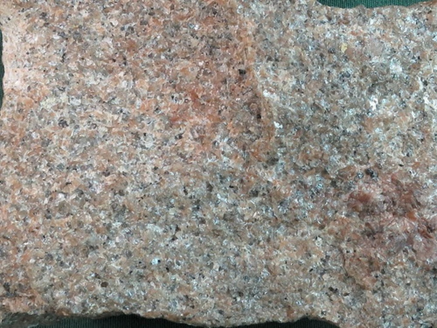 <p>Relatively fine-grained with an even grain size. Pink orthoclase, is abundant, as is gray, glassy quartz, and there is some albite, too. (Plutonic Rock)</p>