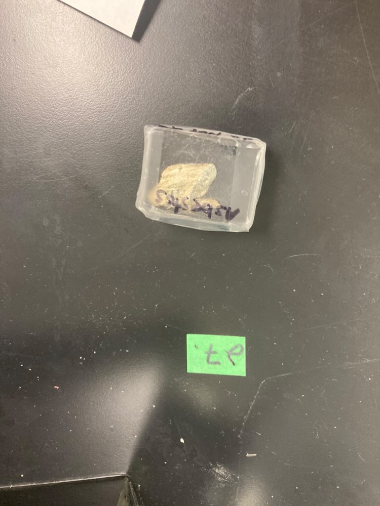<p>DO NOT REMOVE FROM BAG The light grey fibrous vein in this dark rock is is……………………………. Why is this rock enclosed in a bag?………………</p>