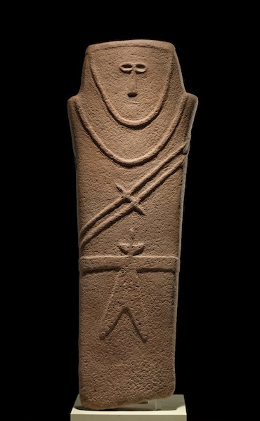 <ul><li><p>Religious or burial purpose, perhaps as a grave marker.</p></li><li><p>Belted robe from which hangs a double-bladed knife or sword. Double cords stretch diagonally across body with an awl unifying them.</p></li></ul>